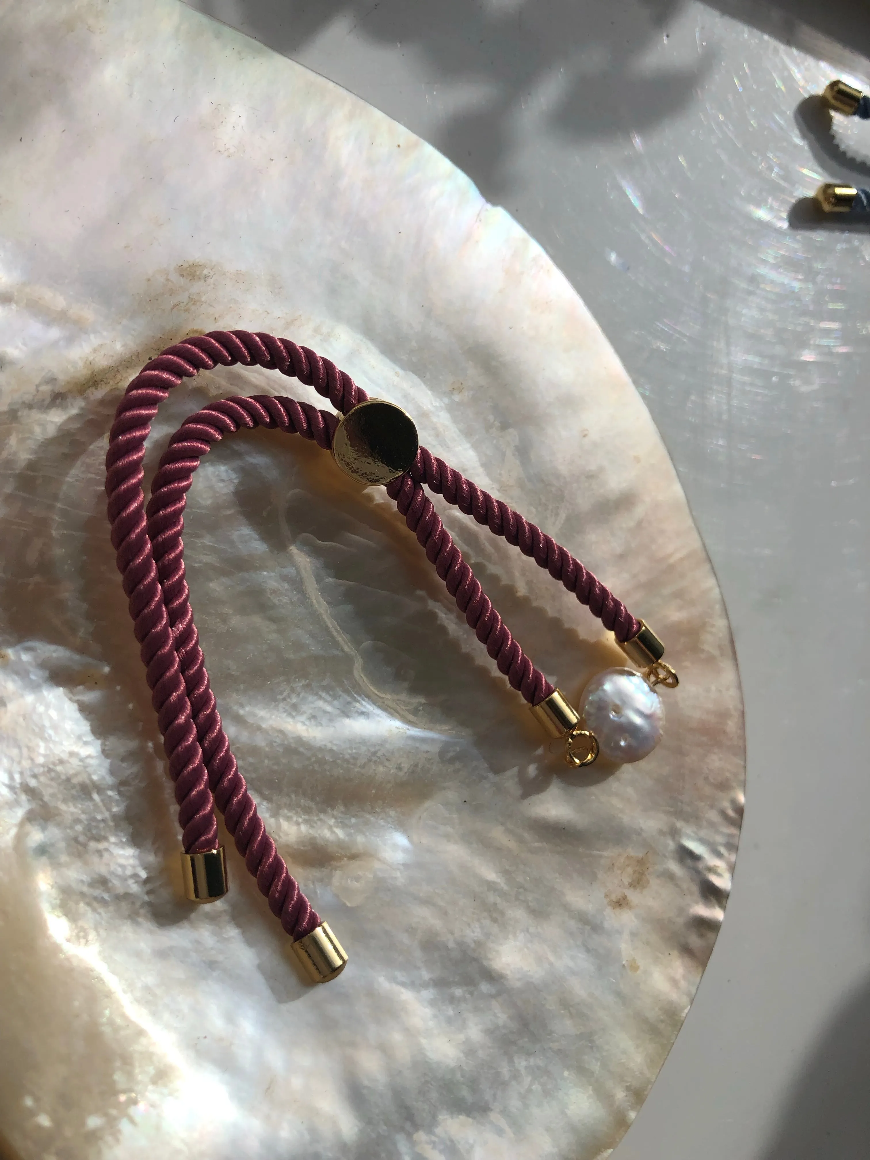 Bracelet: Pearl coin corded slider bracelets in goldtone.