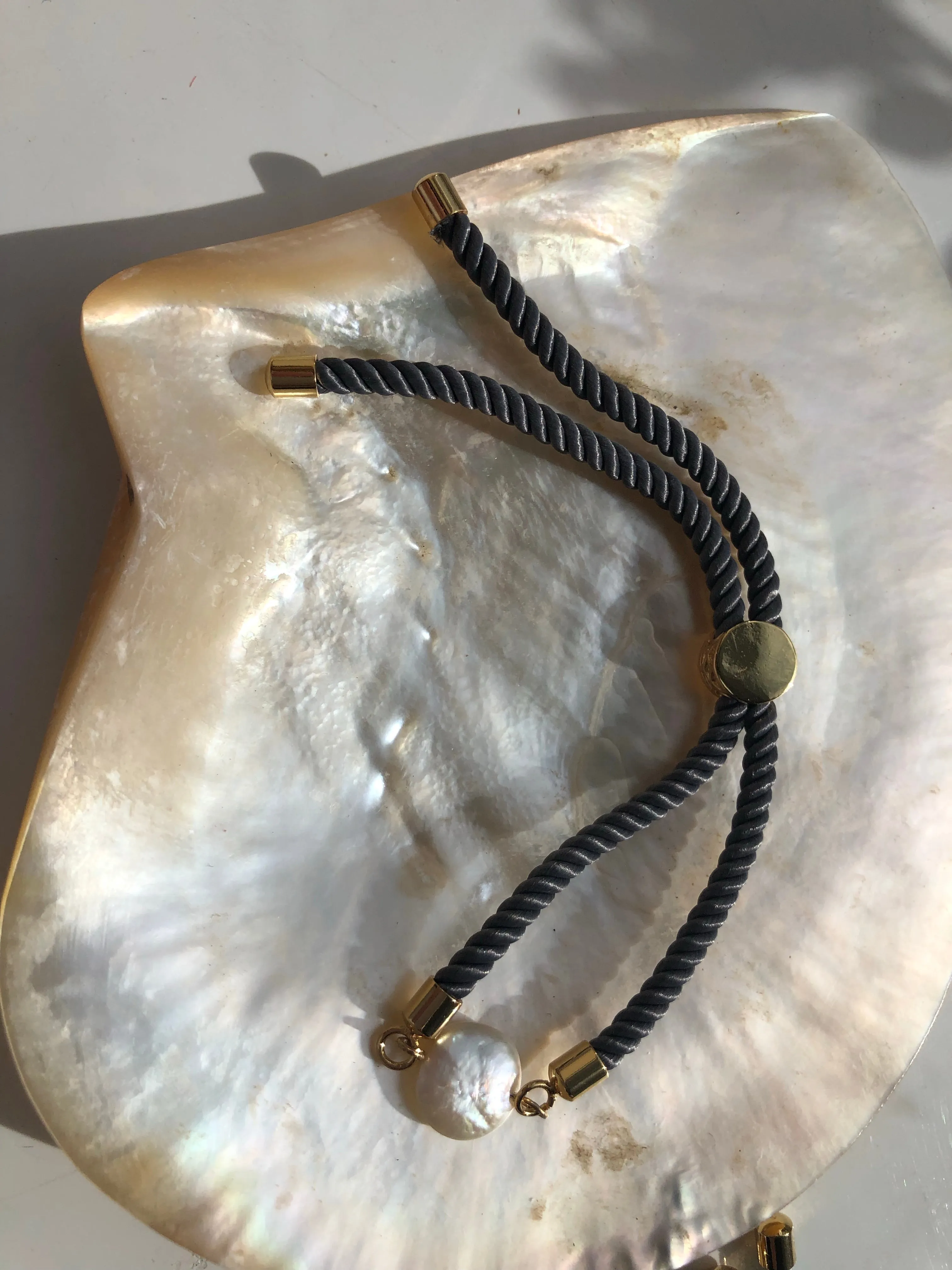 Bracelet: Pearl coin corded slider bracelets in goldtone.