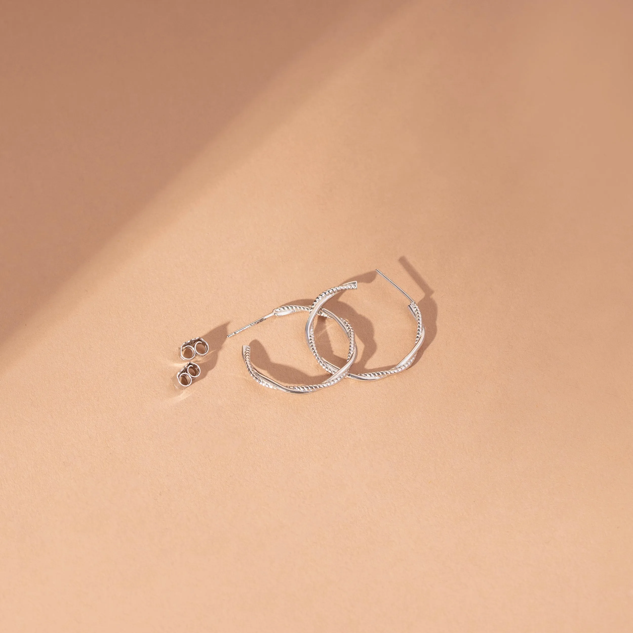 Sleek Silver Twirl Hoop Earrings | SKU: 0003085691, 0019311920, 0019311937